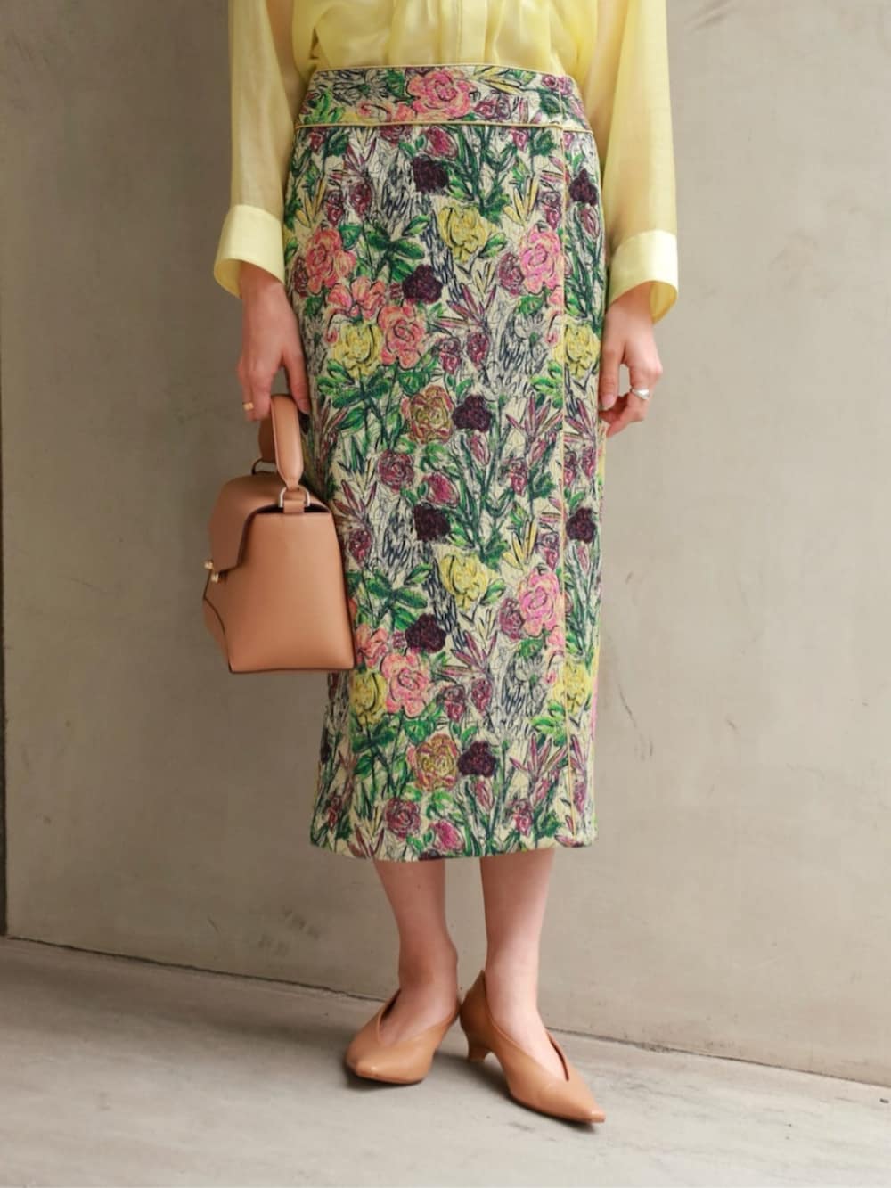 イエロー系のシャツ/ブラウス、ブラック系のベスト、グリーン系のスカートを着用したレディースの春コーディネートの5枚目の写真