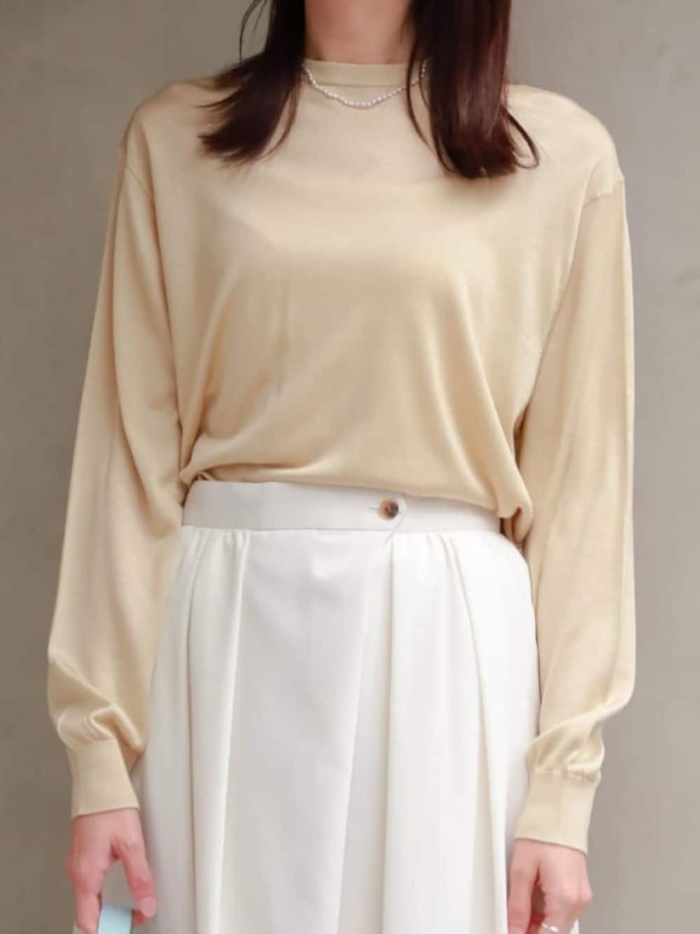 ベージュ系のブルゾン、ベージュ系のニット/セーター、パープル系のネックレスを着用したレディースの冬コーディネートの3枚目の写真