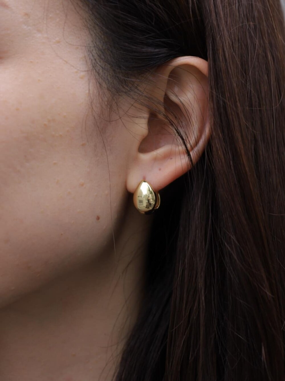 ベージュ系のその他アウター、グレー系のニット/セーター、ホワイト系のクラッチバッグを着用したレディースの秋コーディネートの6枚目の写真