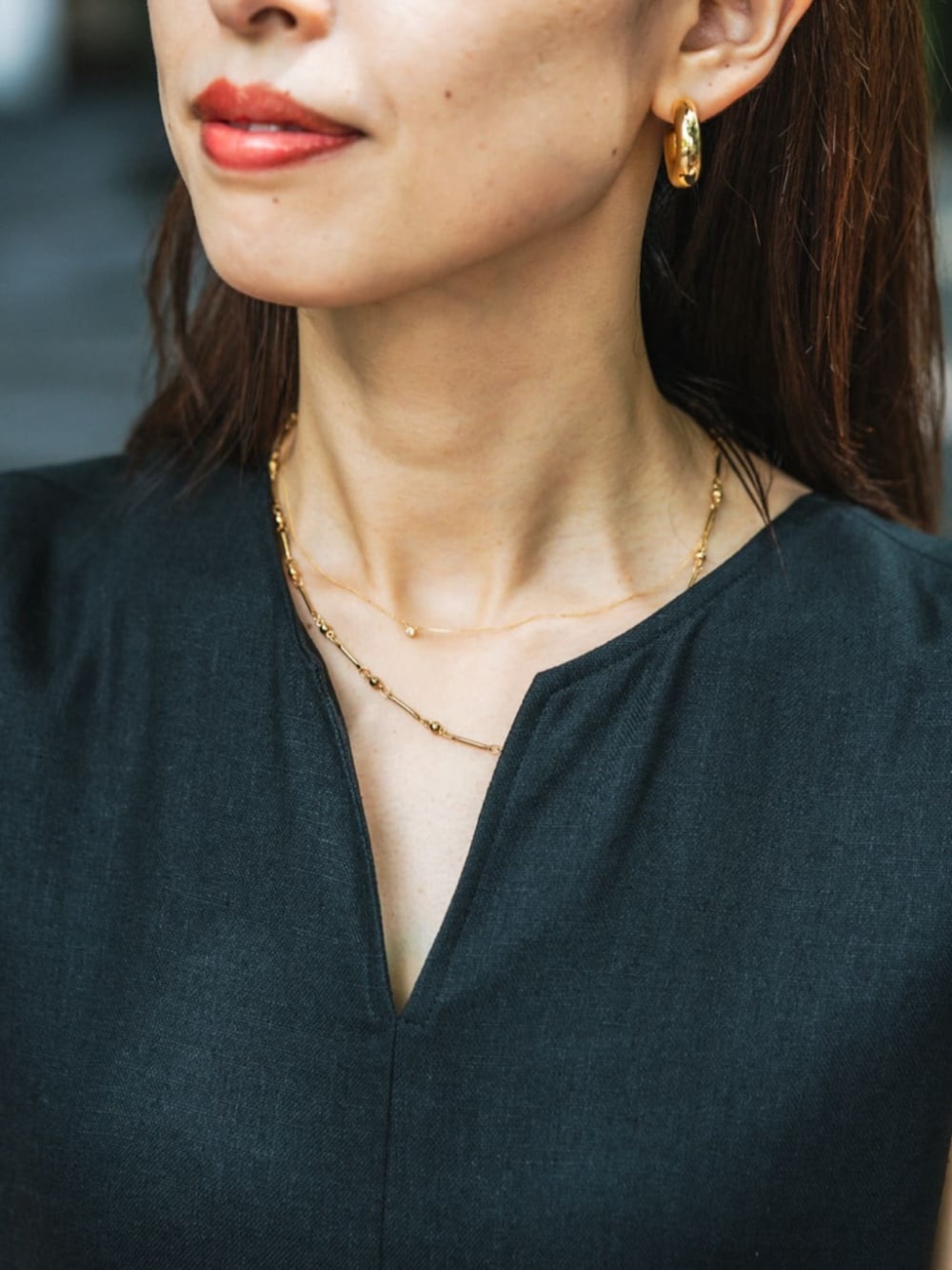 ブラック系のワンピース、ホワイト系のサンダル、ベージュ系のかごバッグを着用したレディースの夏コーディネートの4枚目の写真