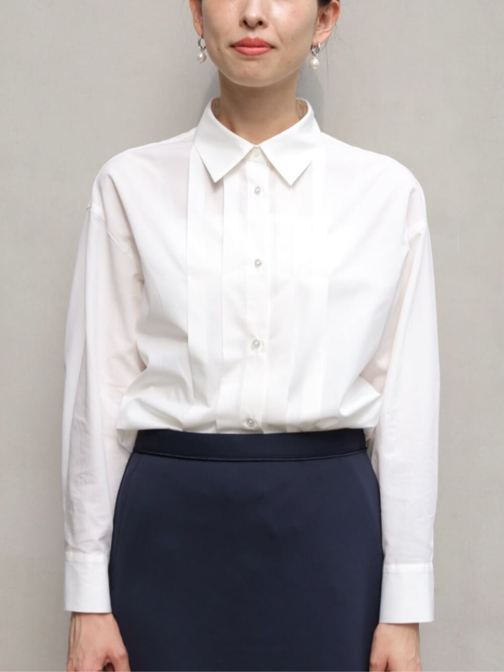 グレー系のパンプス、ブルー系のノーカラージャケット、ブルー系のスカートを着用したレディースの秋コーディネートの4枚目の写真