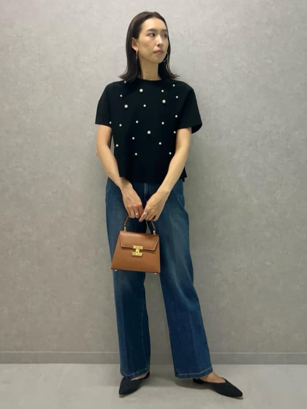 ブルー系のパンプス、ブラック系のブルゾン、ブラック系のニット/セーターを着用したレディースの秋コーディネートの2枚目の写真