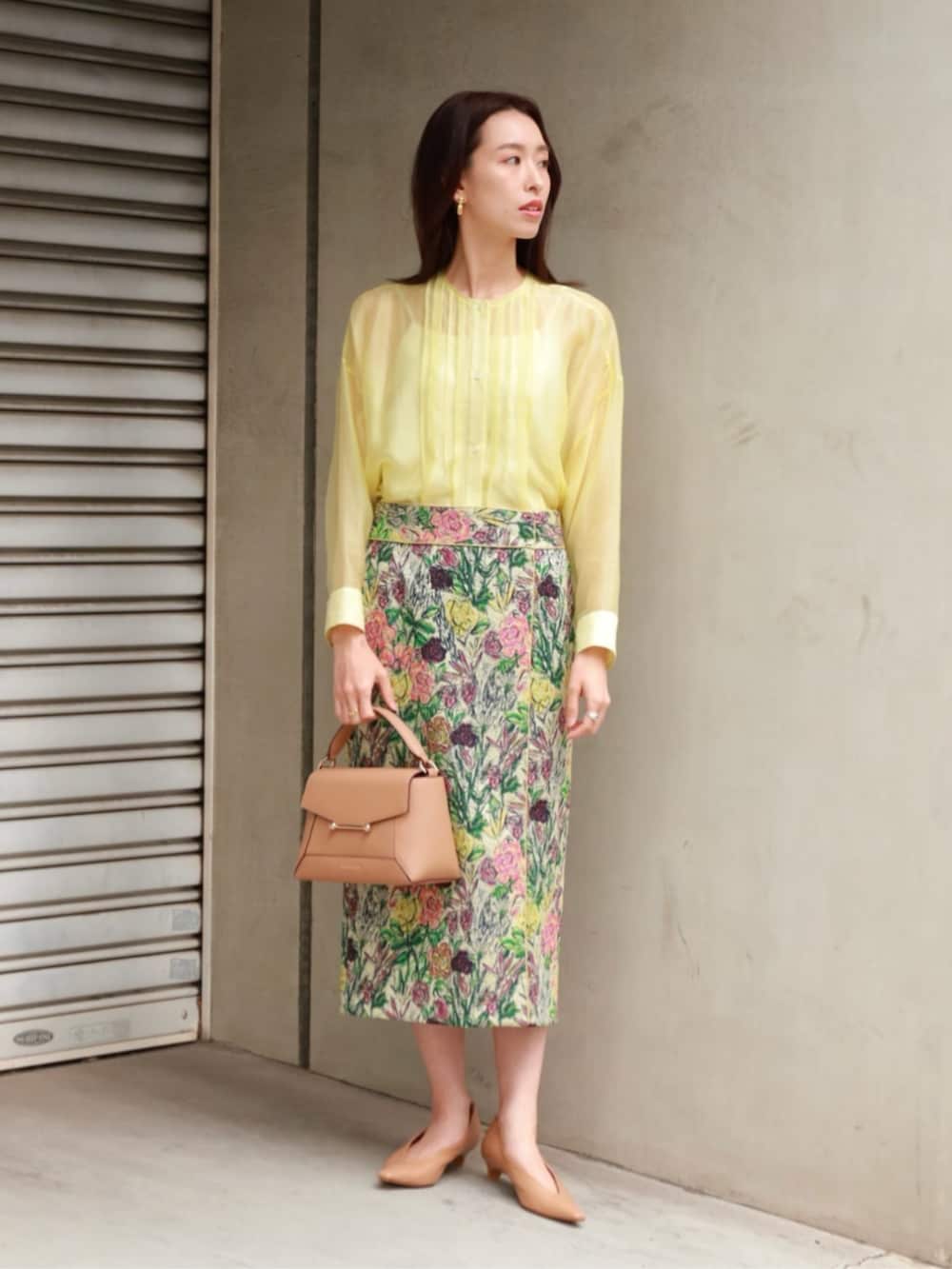 イエロー系のシャツ/ブラウス、ブラック系のベスト、グリーン系のスカートを着用したレディースの春コーディネートの3枚目の写真