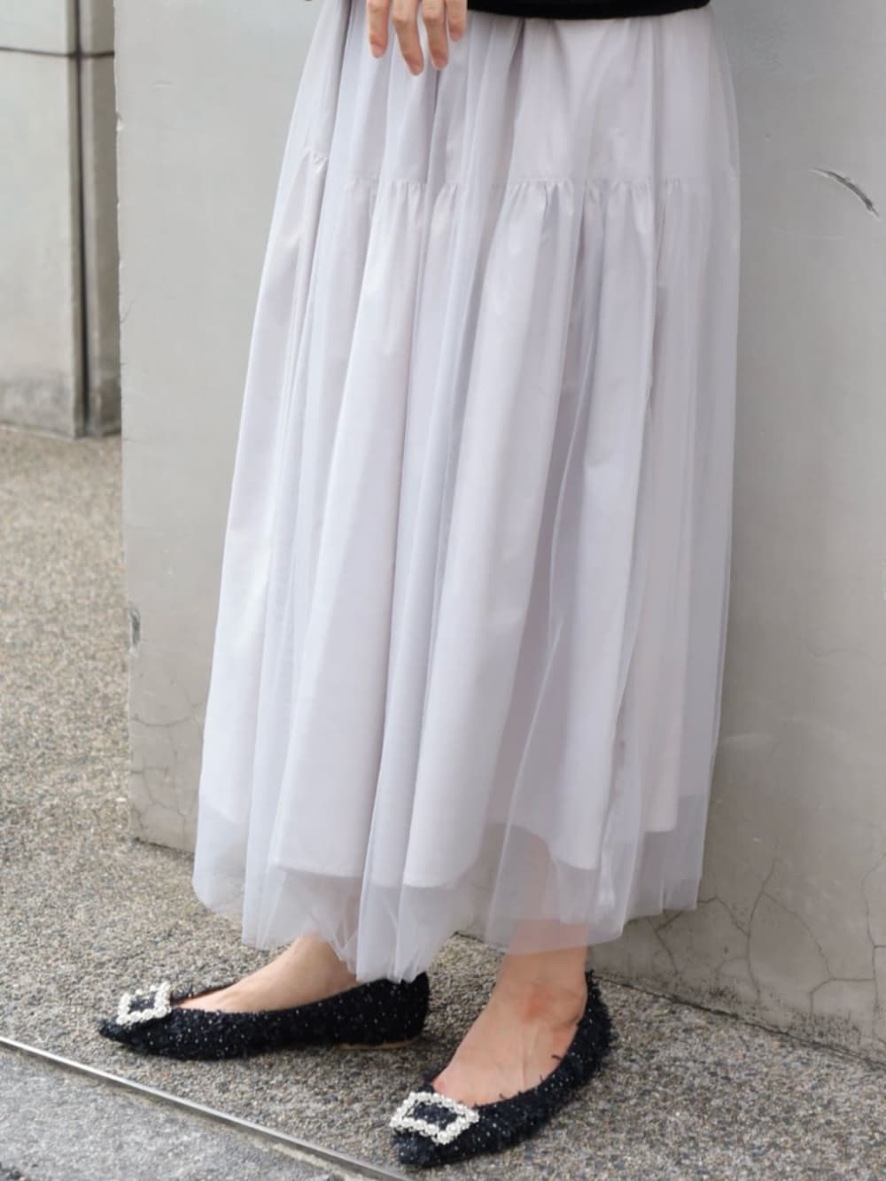 ブラック系のニット/セーター、グレー系のスカート、ホワイト系のピアス（両耳用）を着用したレディースの秋コーディネートの4枚目の写真