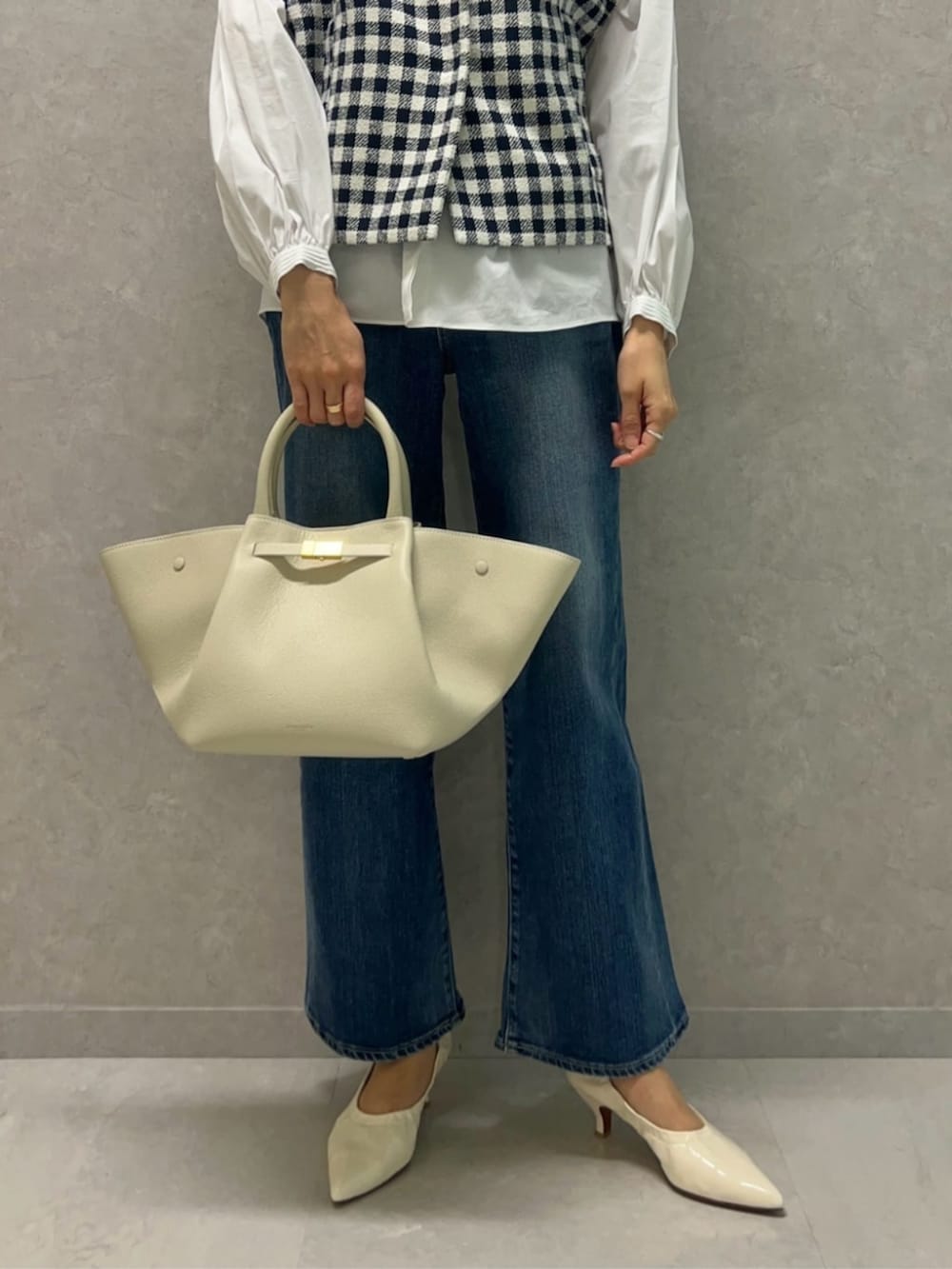 ブルー系のベスト、ホワイト系のシャツ/ブラウス、ブルー系のデニムパンツを着用したレディースの冬コーディネートの3枚目の写真