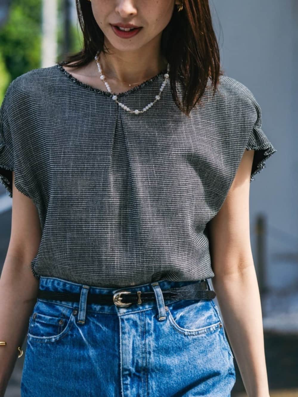 グレー系のシャツ/ブラウス、ブルー系のデニムパンツ、ブラック系のサンダルを着用したレディースの春コーディネートの2枚目の写真