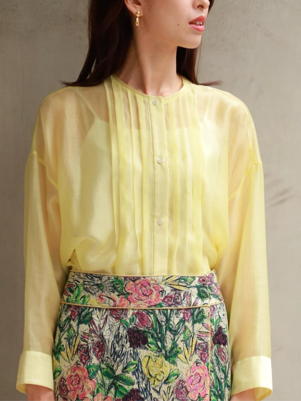 イエロー系のシャツ/ブラウス、ブラック系のベスト、グリーン系のスカートを着用したレディースの春コーディネートの4枚目の写真