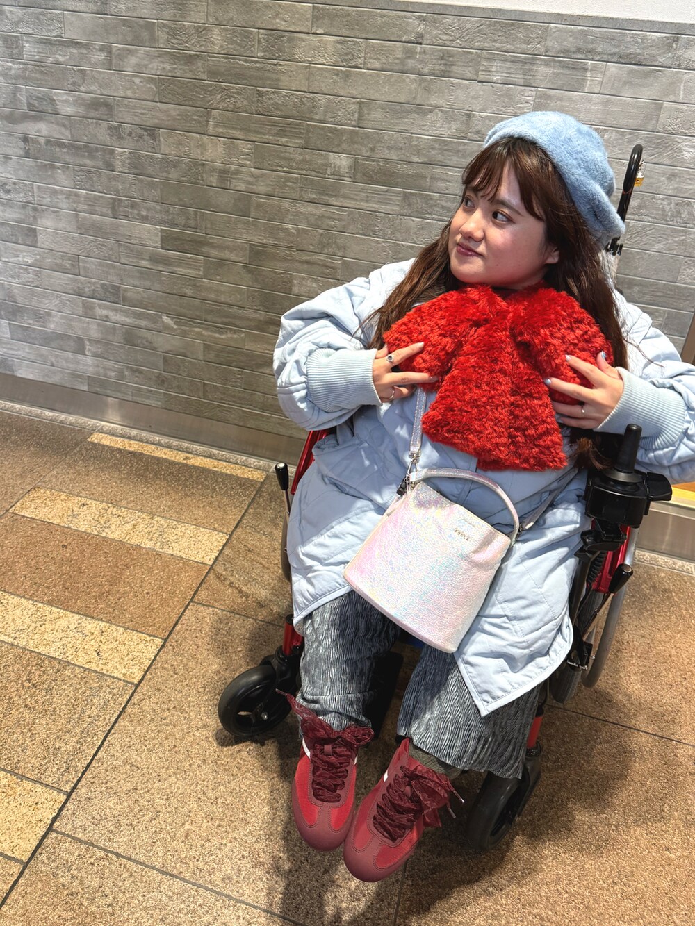 レッド系のスニーカー、ブルー系のハンチング/ベレー帽、レッド系のマフラーを着用したレディースの冬コーディネートの2枚目の写真