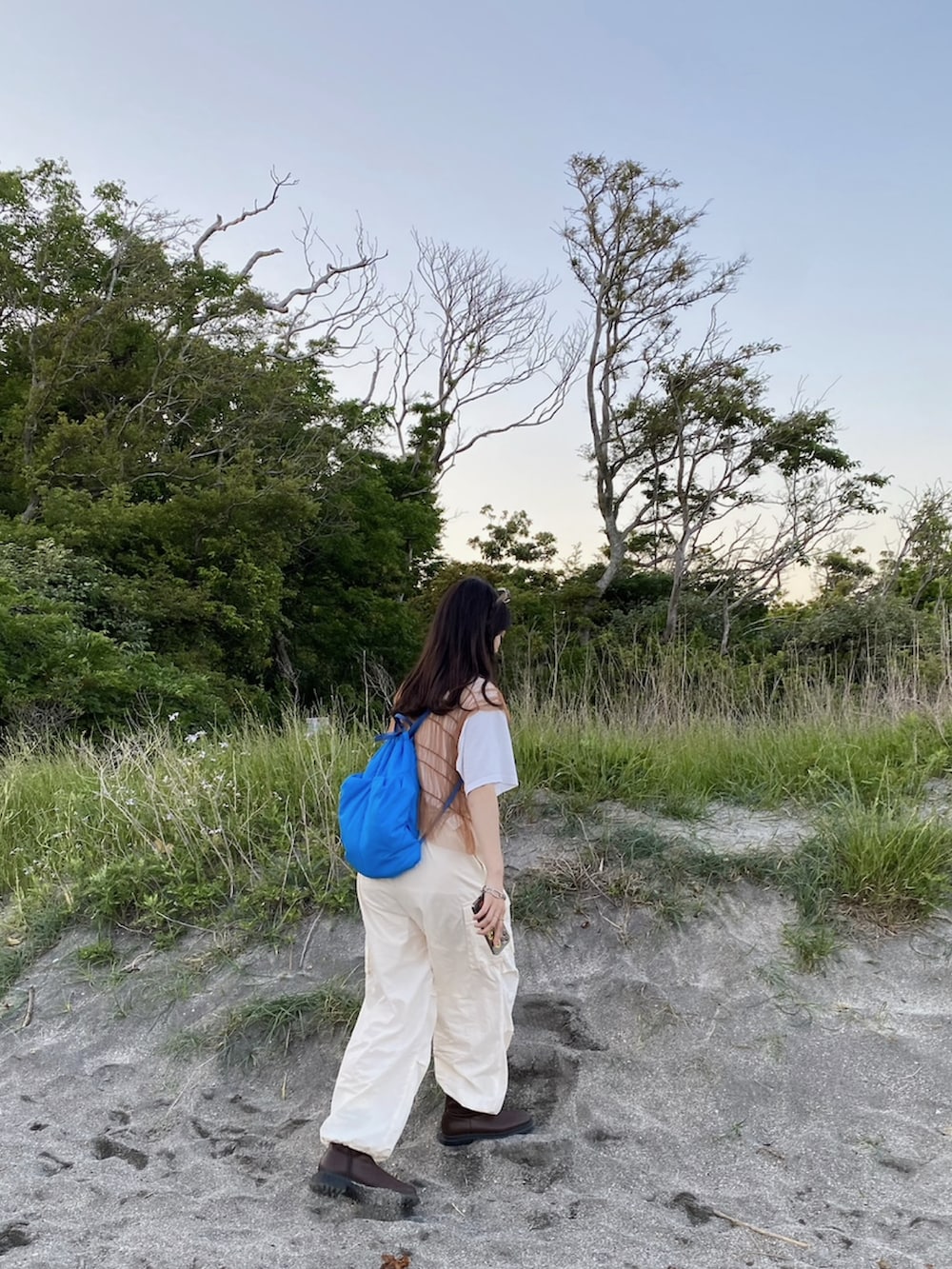 ホワイト系のカーゴパンツ、ブラウン系のTシャツ/カットソー、ブルー系のバックパック/リュックを着用したレディースの春コーディネートの3枚目の写真
