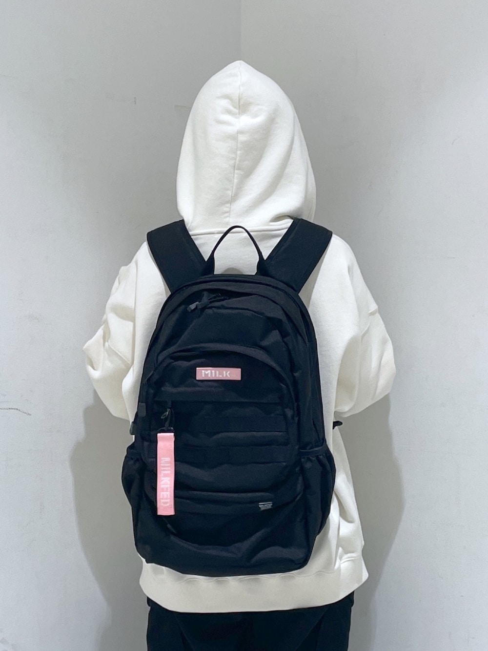 ホワイト系のパーカー、ピンク系のバックパック/リュックを着用したレディースの冬コーディネートの2枚目の写真