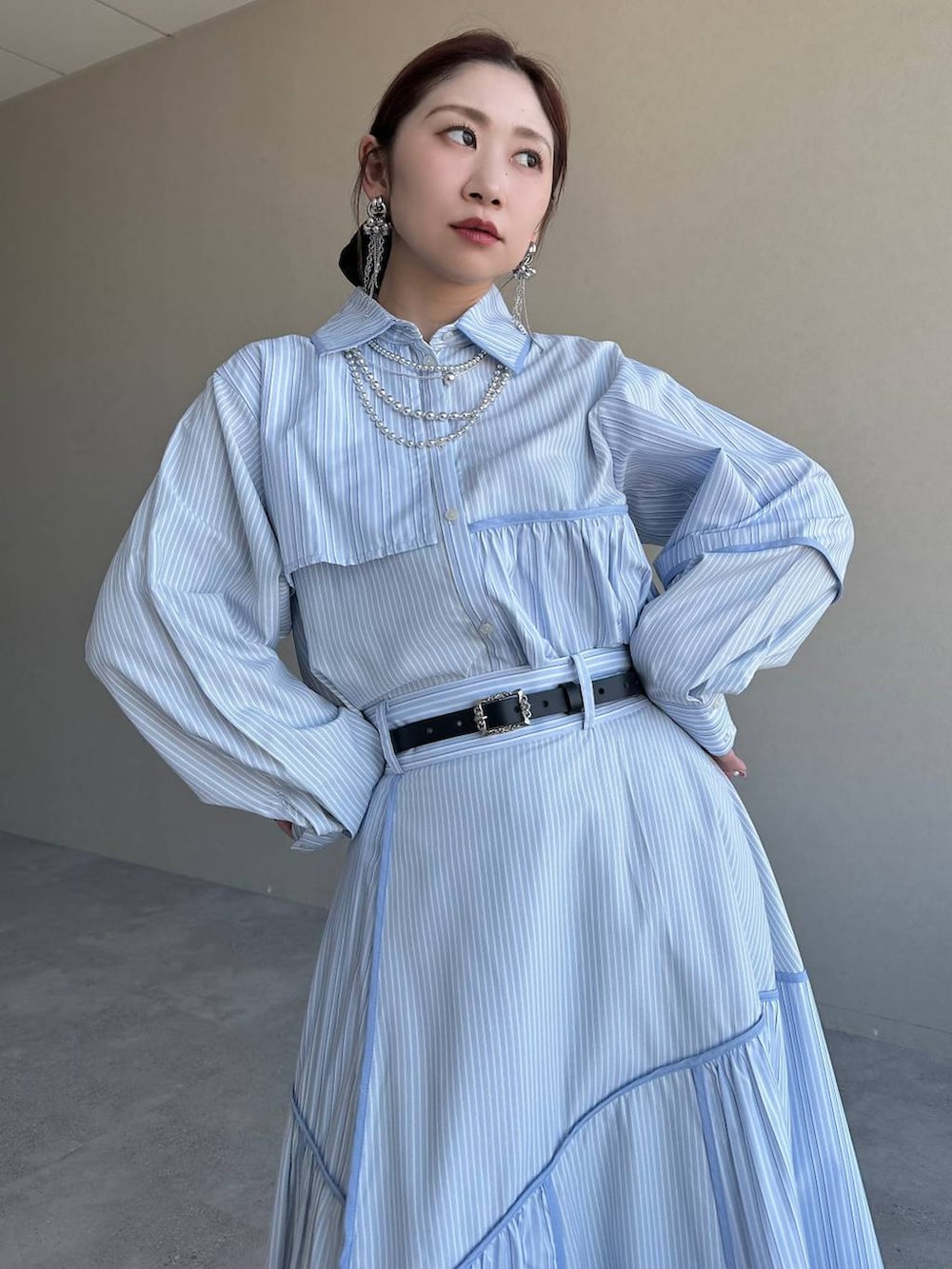 ブラック系のショルダーバッグ、シルバー系のブーツ、ブルー系のスカートを着用したレディースの冬コーディネートの4枚目の写真