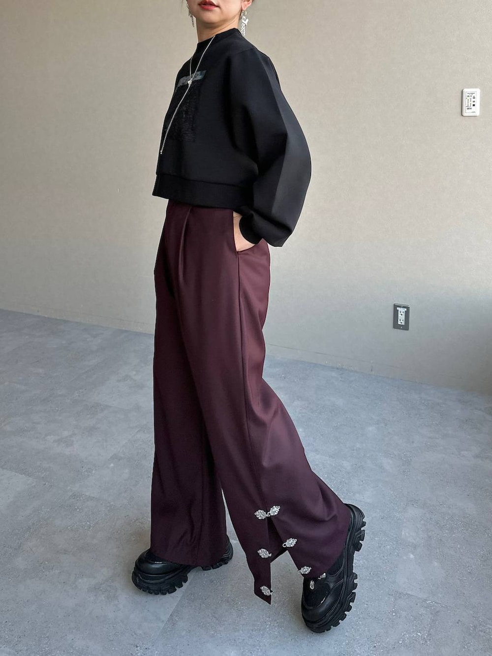 ブラック系のスニーカー、ブラック系のスウェット、レッド系のその他パンツを着用したレディースの冬コーディネートの4枚目の写真