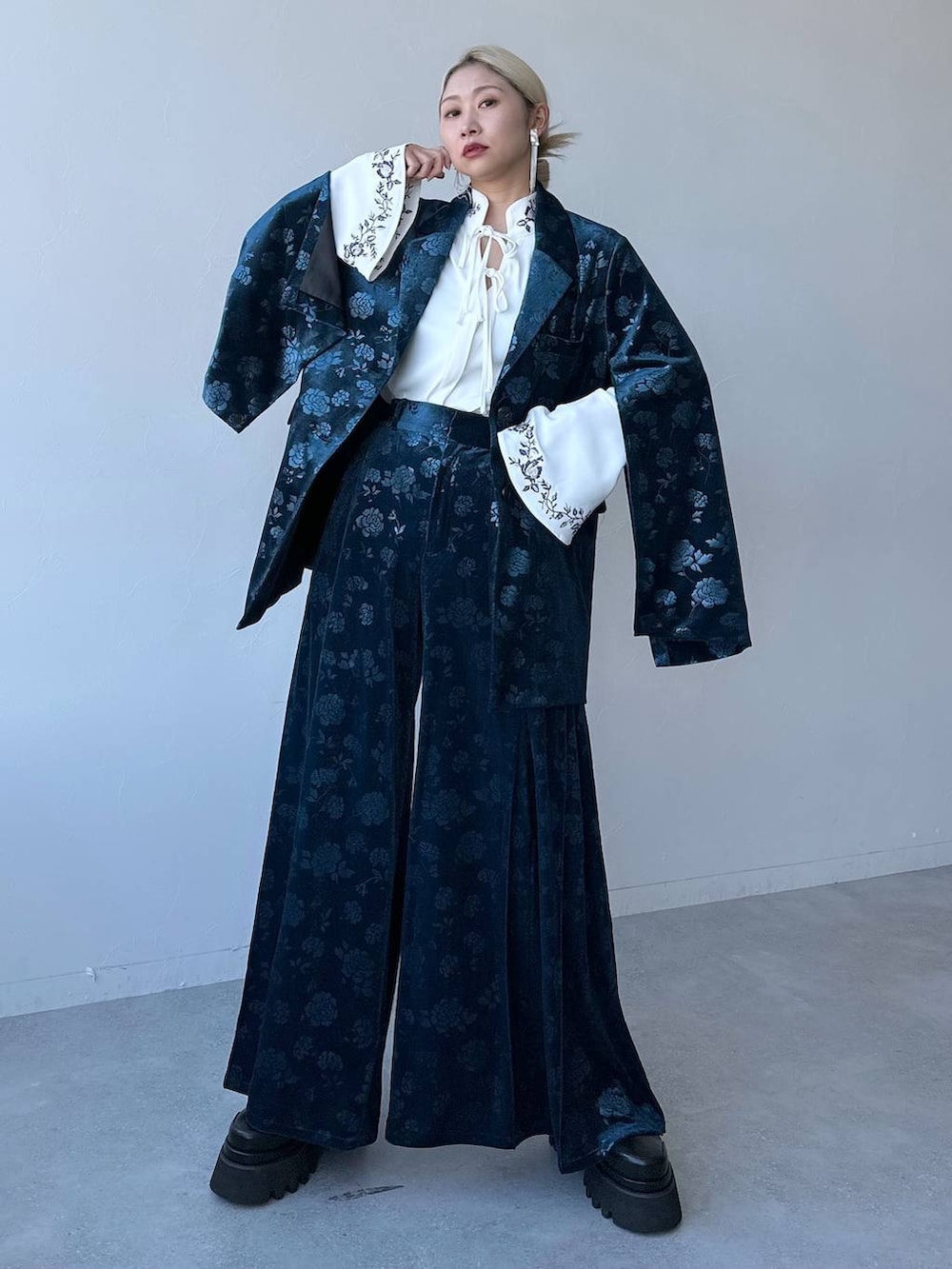 ホワイト系のシャツ/ブラウス、ブルー系のテーラードジャケット、ブラック系のブーツを着用したレディースの冬コーディネートの6枚目の写真