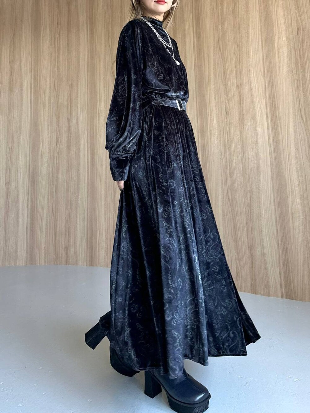 グレー系のワンピース、ブルー系のブーツ、ブラック系のショルダーバッグを着用したレディースの秋コーディネートの3枚目の写真