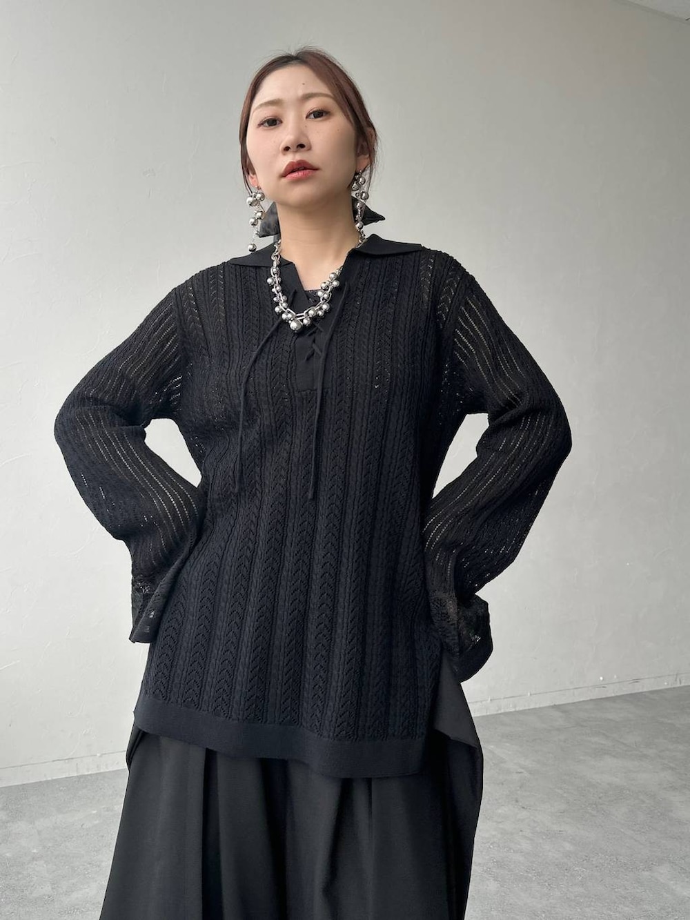 ブラック系のサンダル、ブラック系のニット/セーター、ブラック系のスラックスを着用したレディースの春コーディネートの4枚目の写真