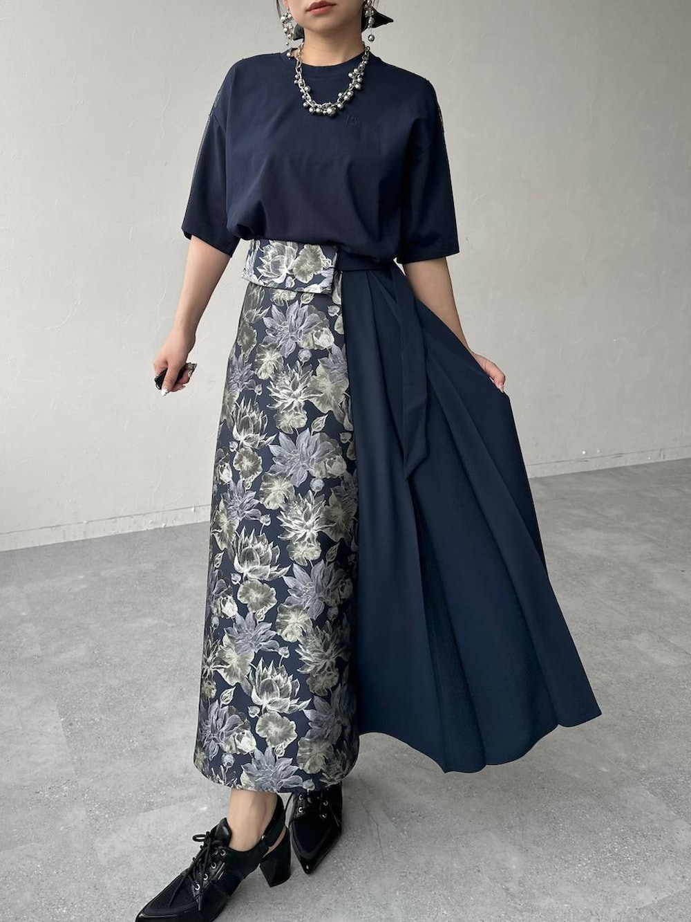 ブラック系のサンダル、ブラック系のハンドバッグ、ブルー系のスカートを着用したレディースの春コーディネートの7枚目の写真