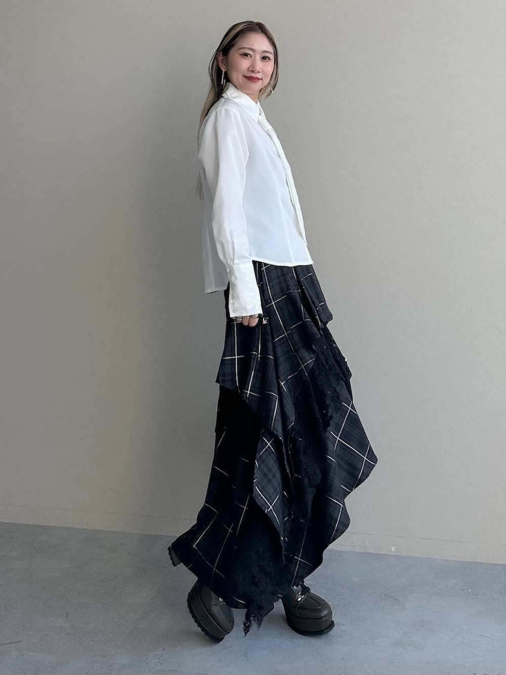 ブラック系のショルダーバッグ、ブラック系のスカート、ホワイト系のシャツ/ブラウスを着用したレディースの夏コーディネートの2枚目の写真