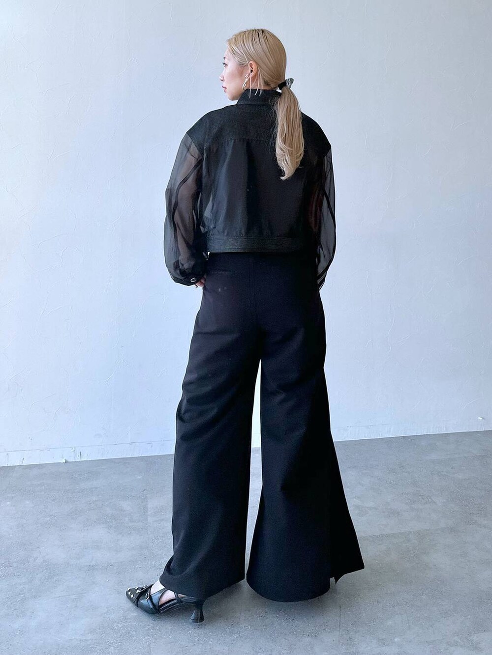 ブラック系のスラックス、ブラック系のパンプス、ブラック系のブルゾンを着用したレディースの夏コーディネートの2枚目の写真