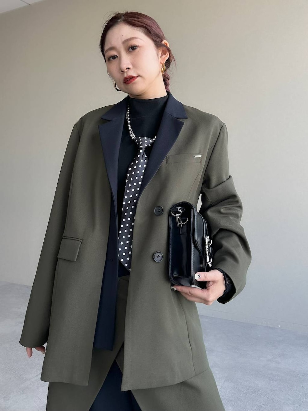 その他のネクタイ、ブラック系のショルダーバッグ、ブラック系のローファーを着用したレディースの冬コーディネートの3枚目の写真