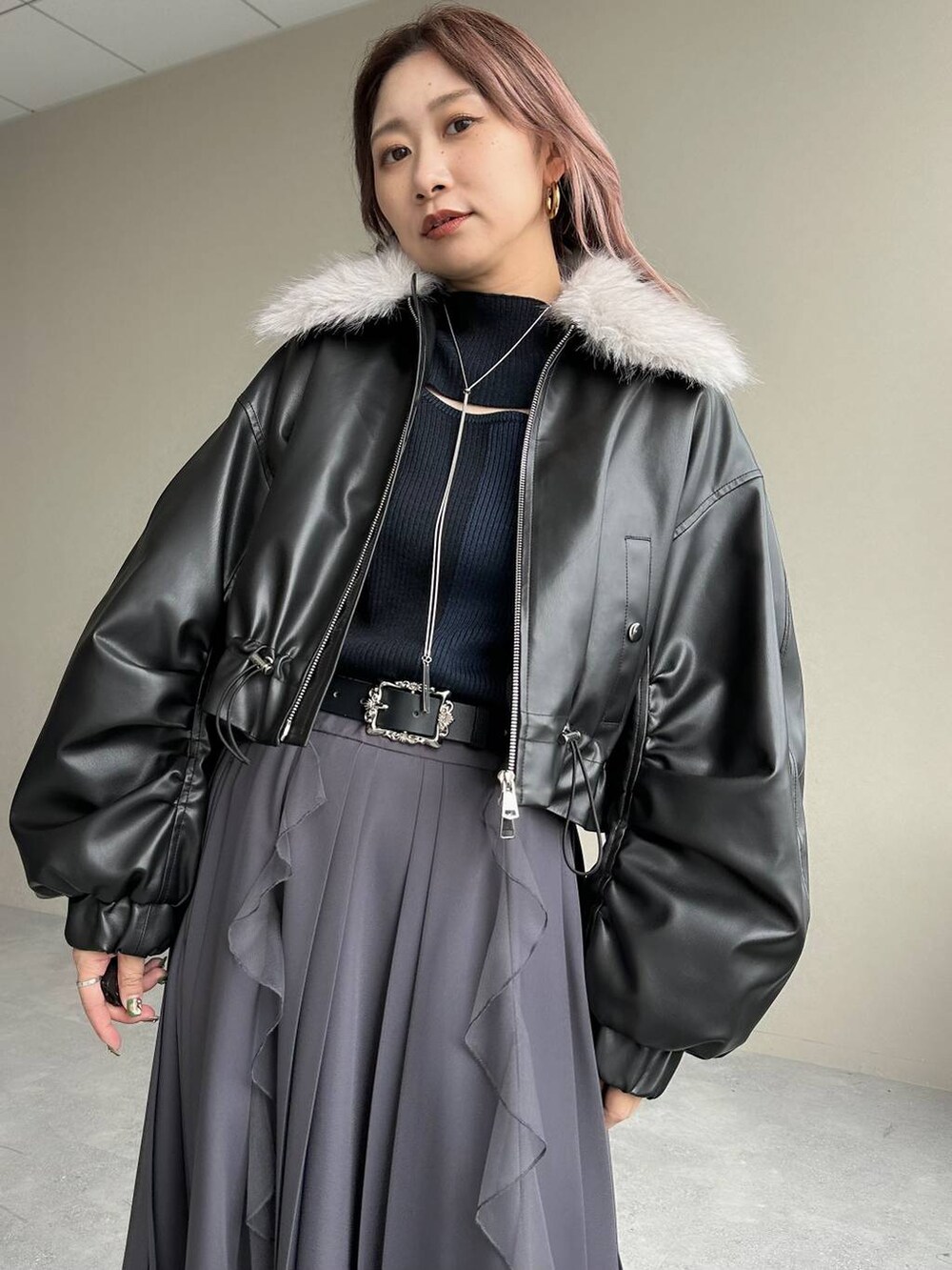 シルバー系のブーツ、ブラック系のニット/セーター、ブラック系のベルトを着用したレディースの秋コーディネートの4枚目の写真