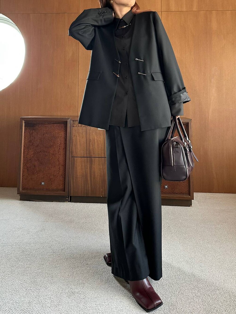 ブラウン系のボストンバッグ、レッド系のブーツを着用したレディースの秋コーディネートの9枚目の写真