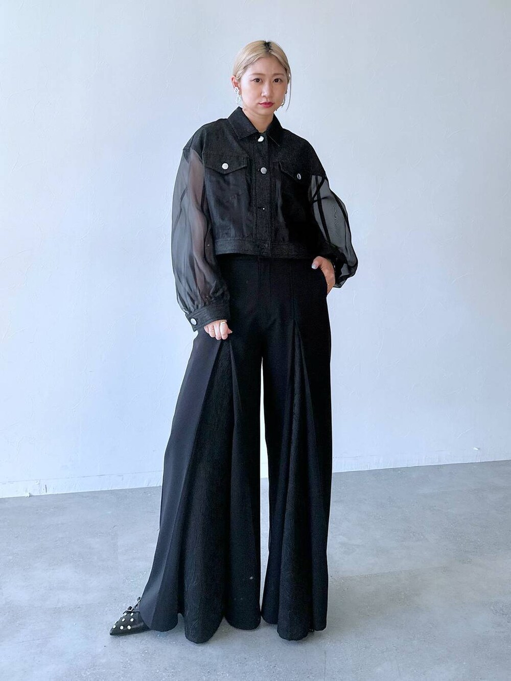 ブラック系のスラックス、ブラック系のパンプス、ブラック系のブルゾンを着用したレディースの夏コーディネートの8枚目の写真