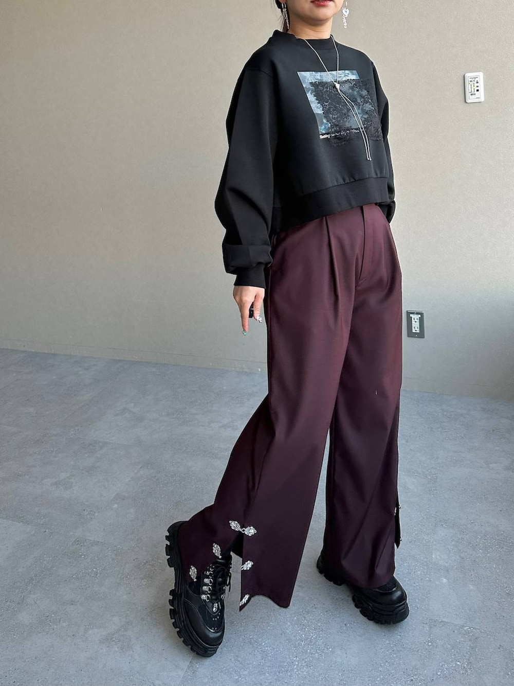 ブラック系のスニーカー、ブラック系のスウェット、レッド系のその他パンツを着用したレディースの冬コーディネートの5枚目の写真