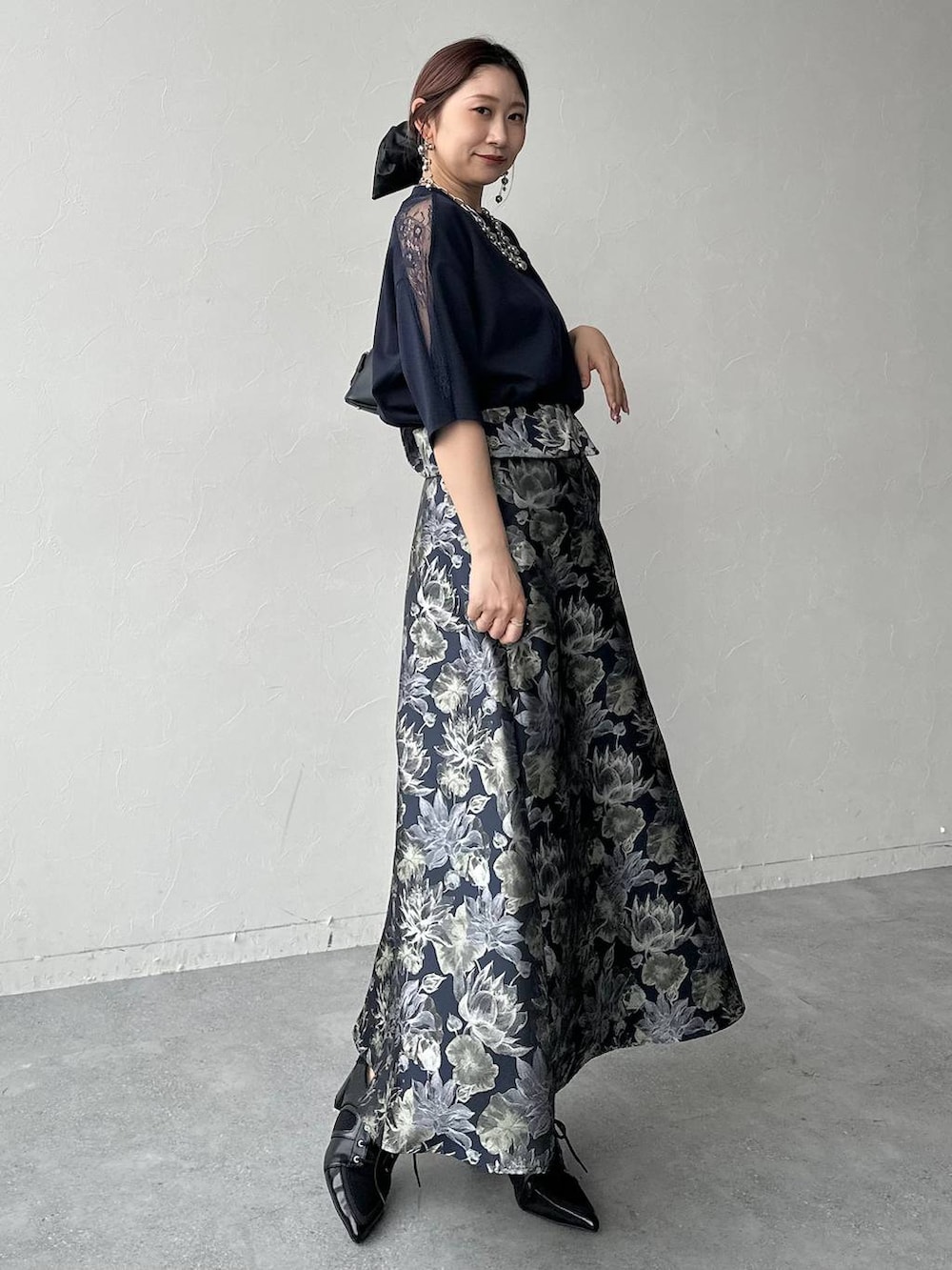 ブラック系のサンダル、ブラック系のハンドバッグ、ブルー系のスカートを着用したレディースの春コーディネートの9枚目の写真