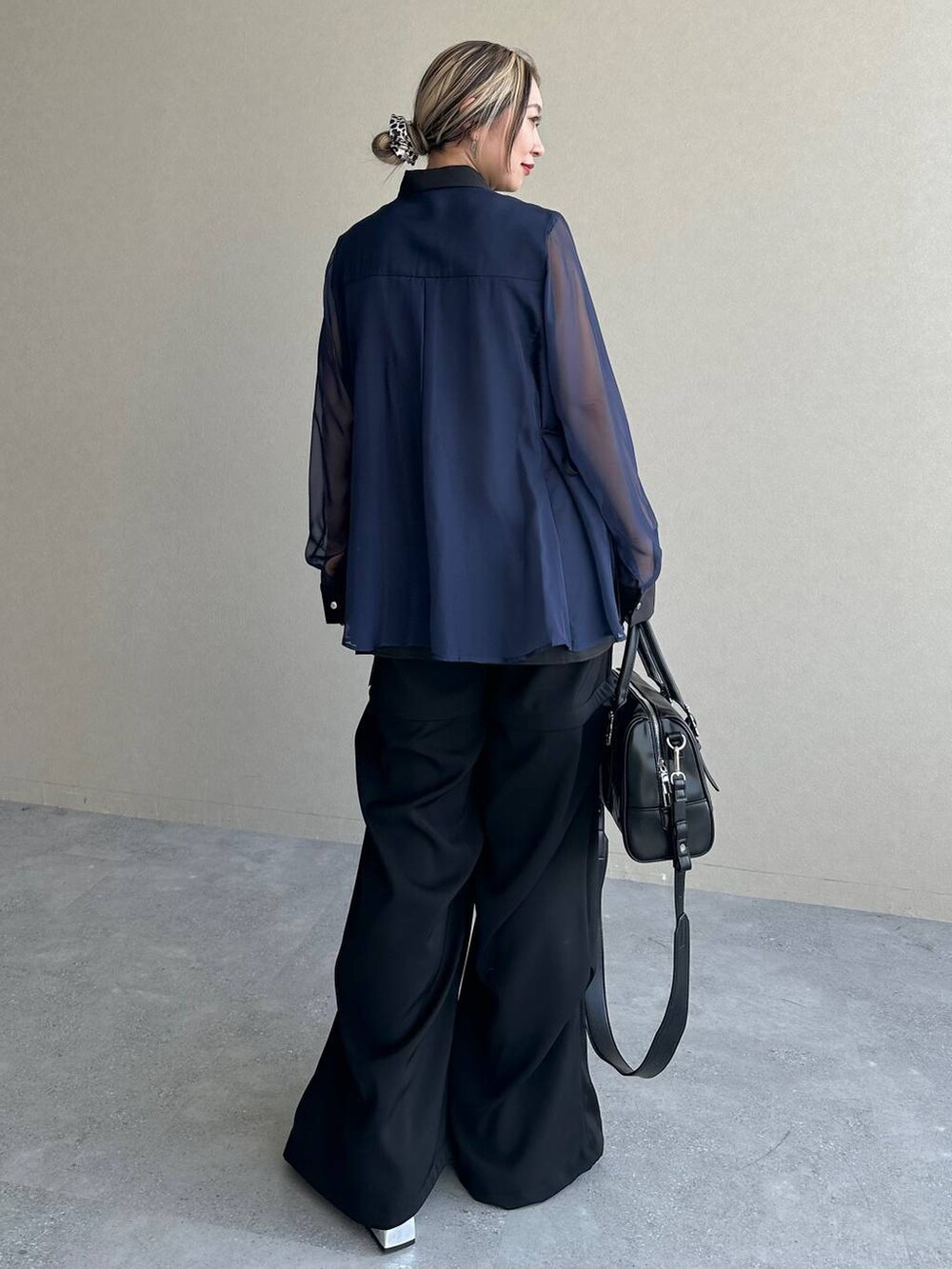 ブラック系のカーゴパンツ、ブラック系のボストンバッグ、シルバー系のブーツを着用したレディースの夏コーディネートの2枚目の写真