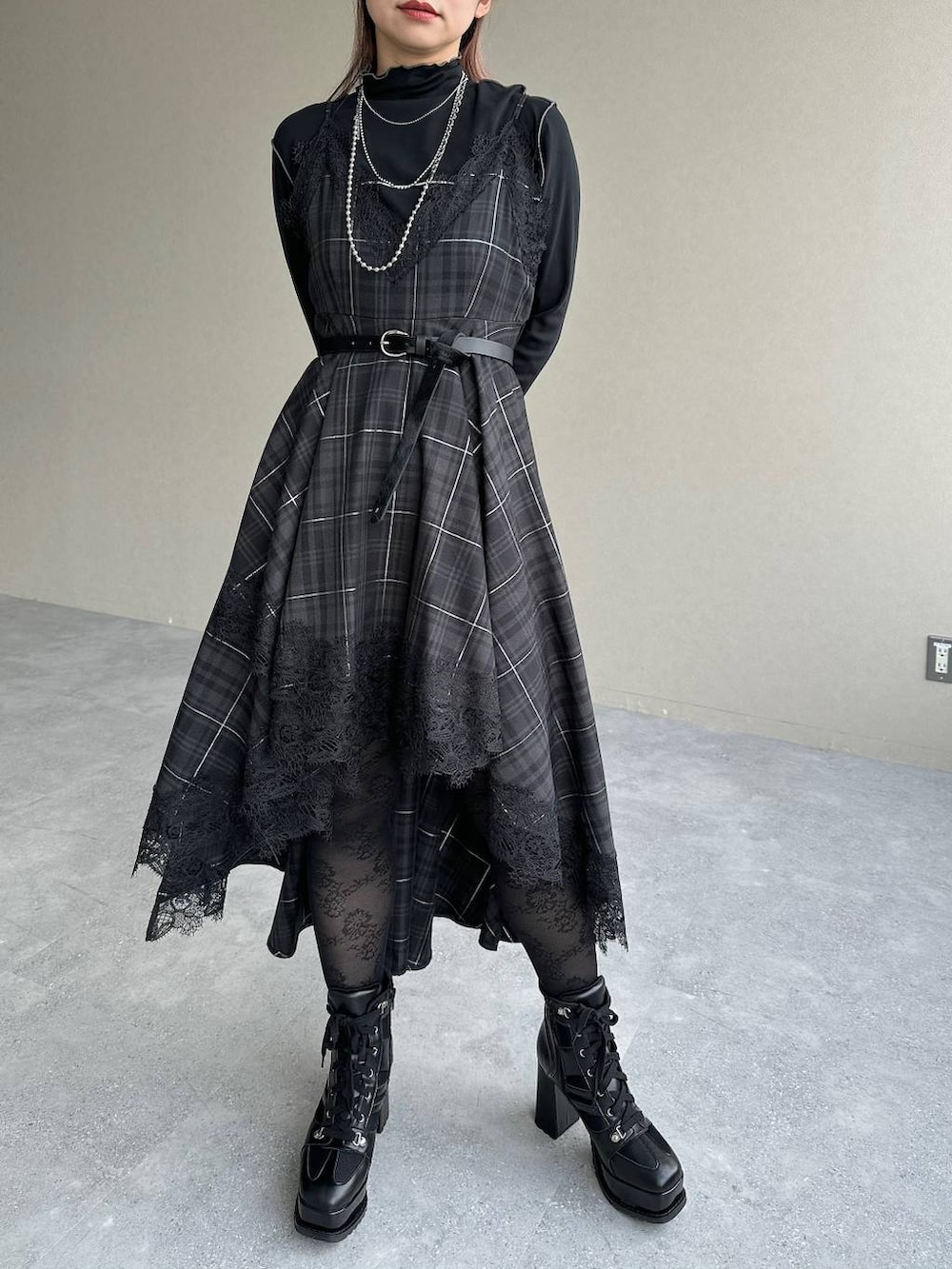 ブラック系のボストンバッグ、ブラック系のワンピース、ブラック系のブーツを着用したレディースの秋コーディネートの7枚目の写真