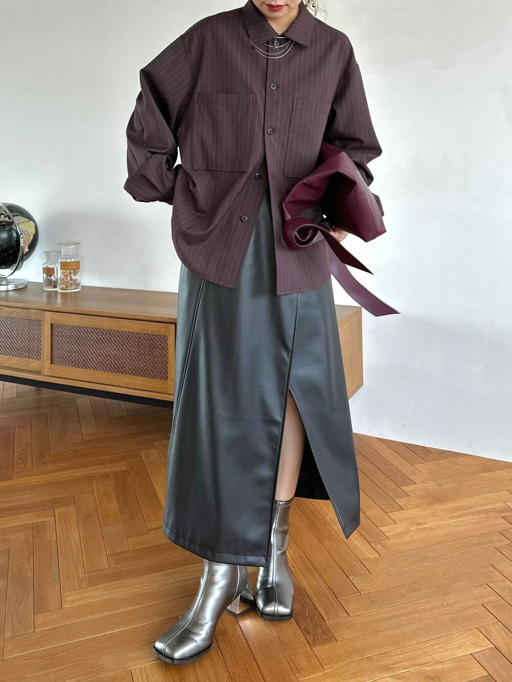 レッド系のトートバッグ、ブラック系のスカート、シルバー系のブーツを着用したレディースの夏コーディネートの8枚目の写真