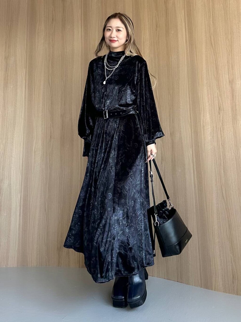 グレー系のワンピース、ブルー系のブーツ、ブラック系のショルダーバッグを着用したレディースの秋コーディネートの6枚目の写真