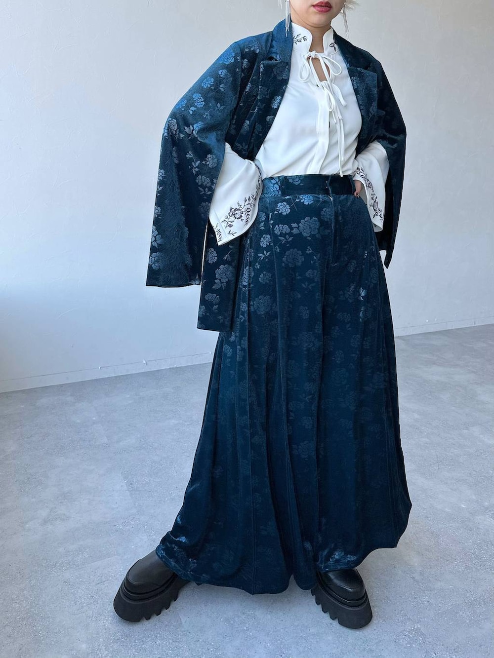 ホワイト系のシャツ/ブラウス、ブルー系のテーラードジャケット、ブラック系のブーツを着用したレディースの冬コーディネートの4枚目の写真