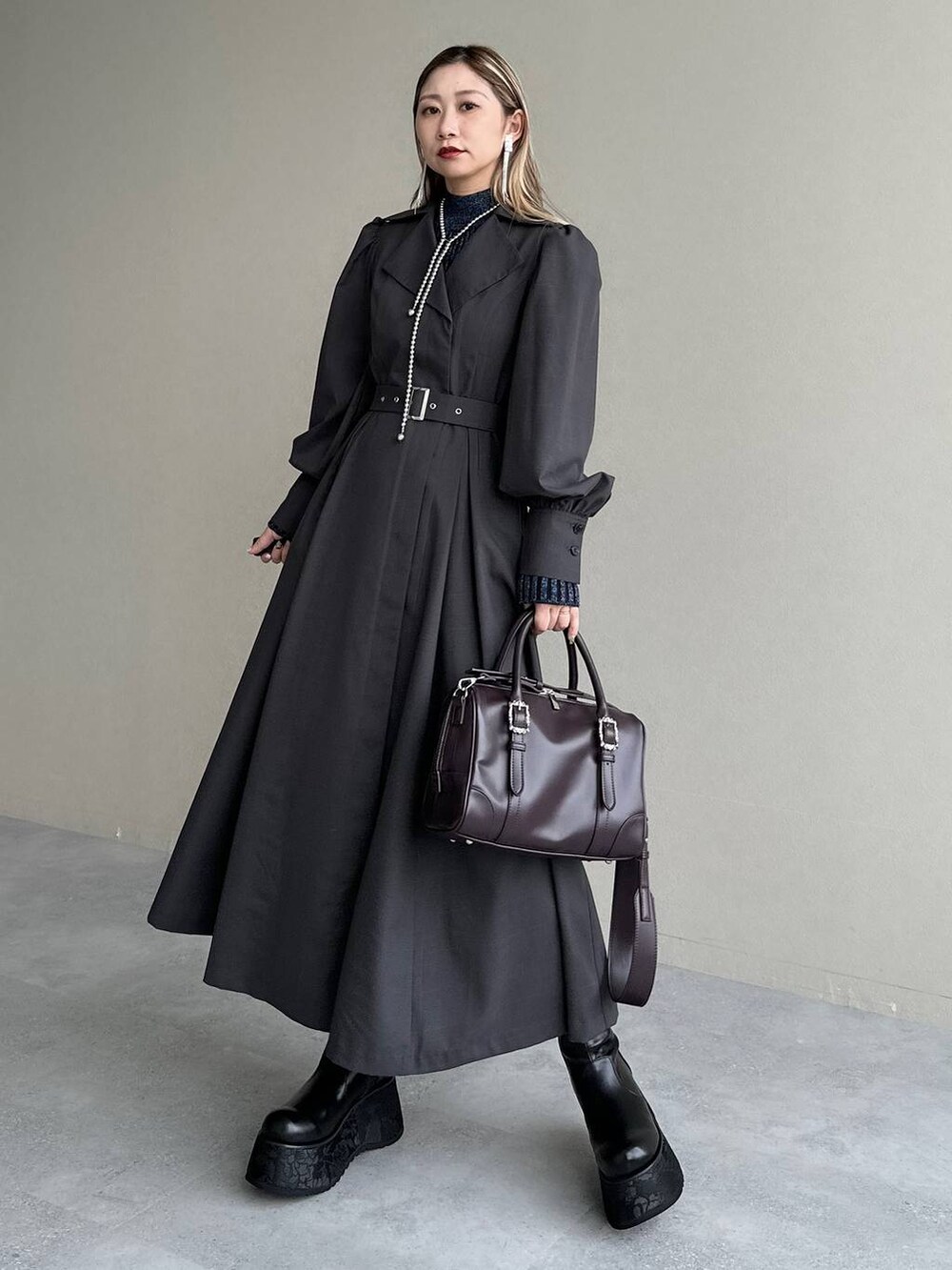 ブルー系のニット/セーター、ブラウン系のボストンバッグ、グレー系のワンピースを着用したレディースの秋コーディネートの8枚目の写真