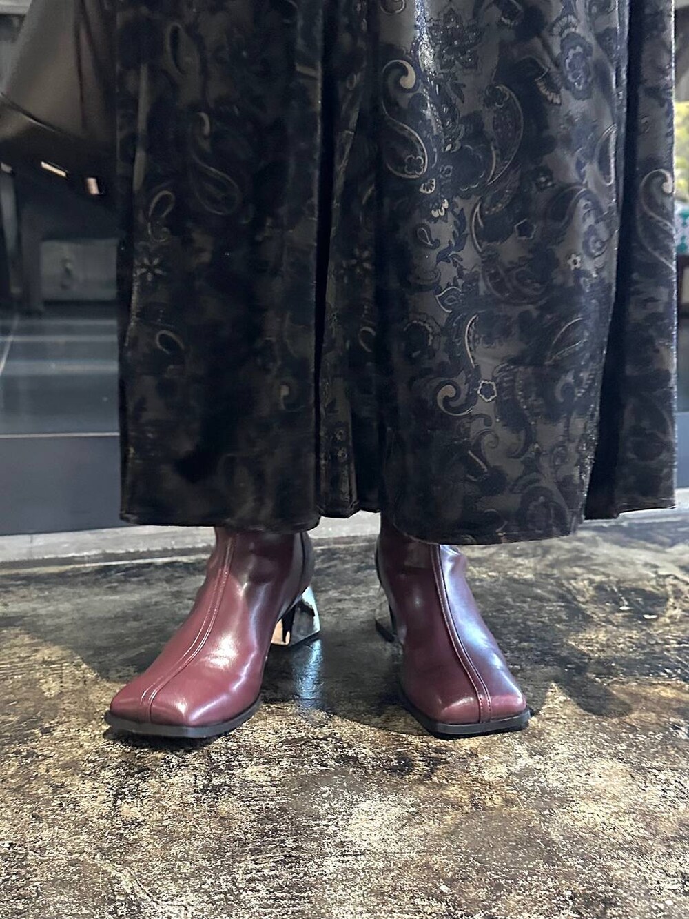 ブラック系のワンピース、レッド系のブーツ、ブラック系のショルダーバッグを着用したレディースの秋コーディネートの8枚目の写真