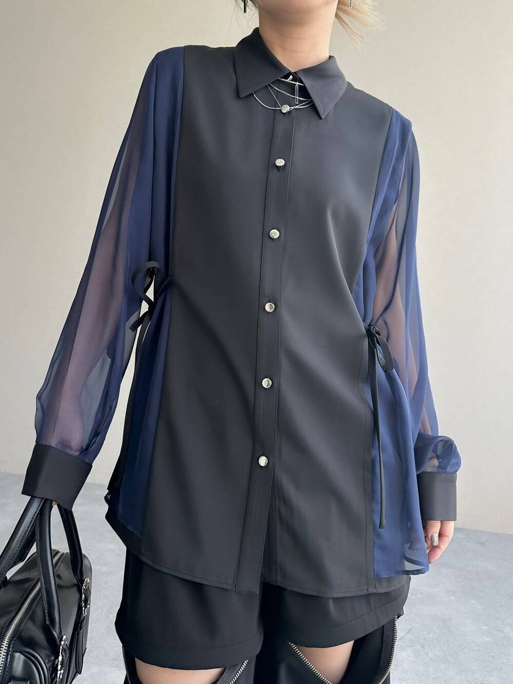 ブラック系のカーゴパンツ、ブラック系のボストンバッグ、シルバー系のブーツを着用したレディースの夏コーディネートの6枚目の写真