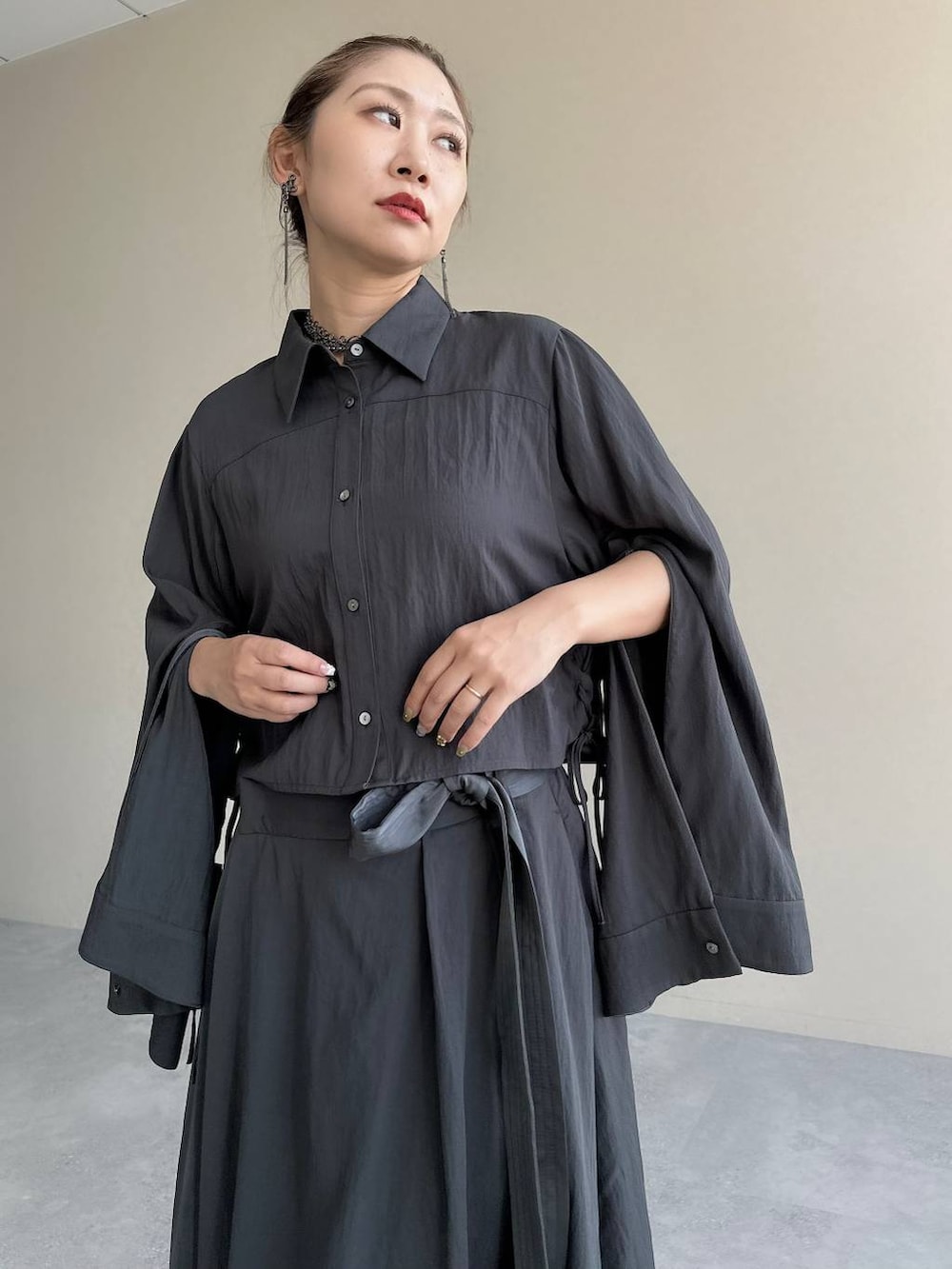 ブラック系のブーツ、グレー系のスカート、グレー系のシャツ/ブラウスを着用したレディースの秋コーディネートの9枚目の写真