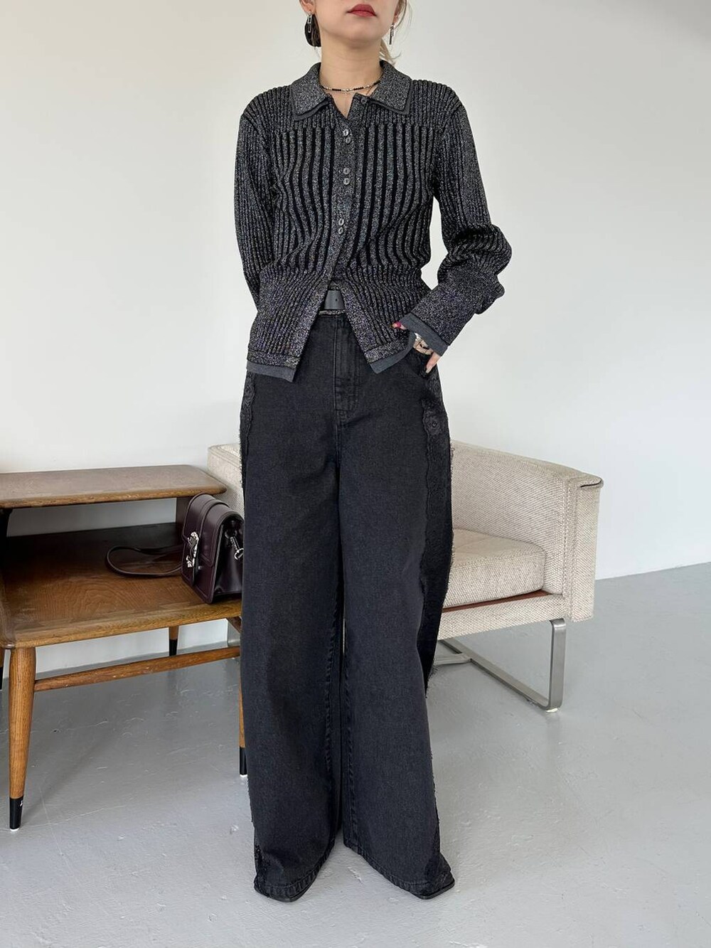 ブラック系のショルダーバッグ、ブラック系のデニムパンツ、ブラック系のブーツを着用したレディースの秋コーディネートの6枚目の写真