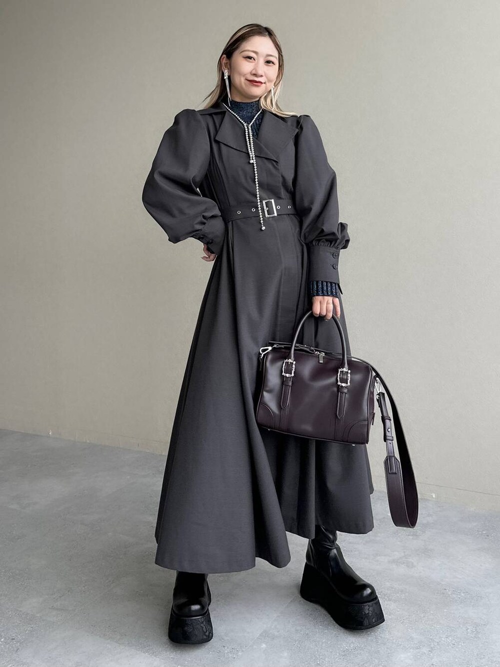 ブルー系のニット/セーター、ブラウン系のボストンバッグ、グレー系のワンピースを着用したレディースの秋コーディネートの7枚目の写真