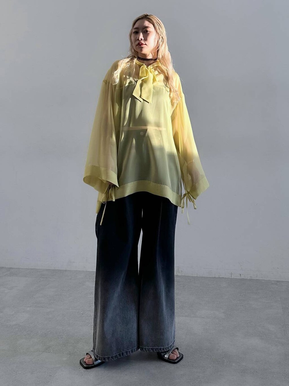 シルバー系のサンダル、ブラック系のデニムパンツ、イエロー系のTシャツ/カットソーを着用したレディースの春コーディネートの9枚目の写真