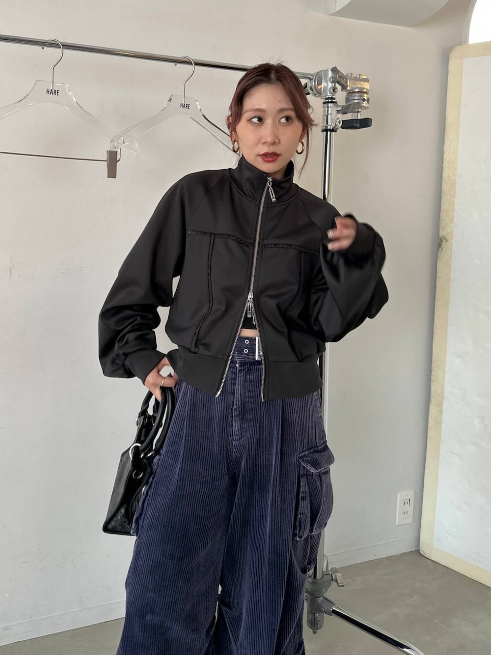 ブラック系のショルダーバッグ、ブルー系のパーカー、ブルー系のカーゴパンツを着用したレディースの秋コーディネートの3枚目の写真