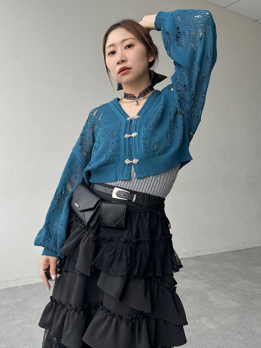 ブラック系のスカート、ブラック系のサンダル、ブルー系のデニムパンツを着用したレディースの春コーディネートの5枚目の写真