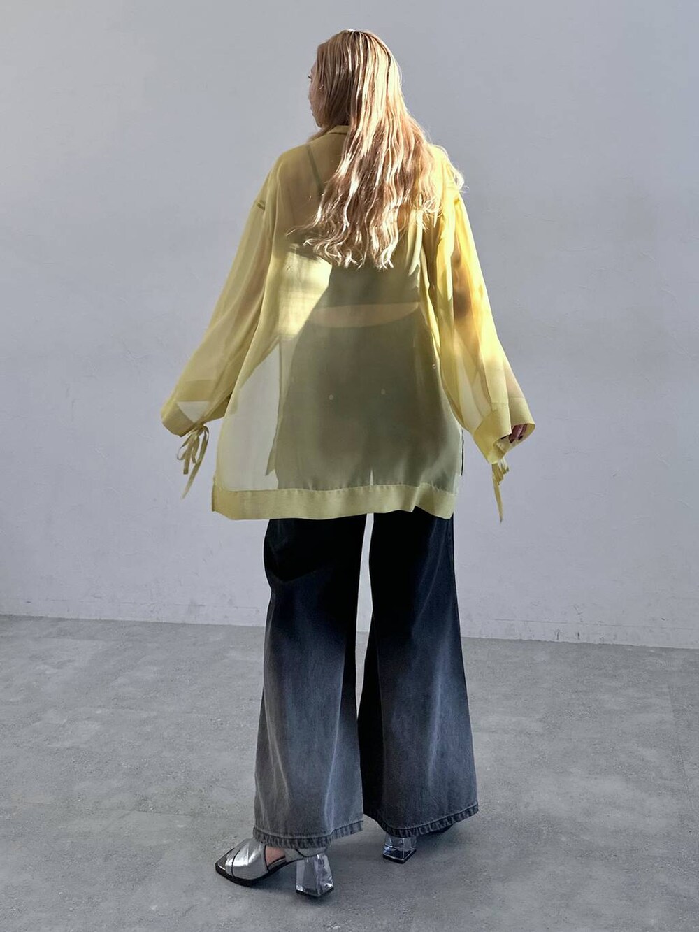 シルバー系のサンダル、ブラック系のデニムパンツ、イエロー系のTシャツ/カットソーを着用したレディースの春コーディネートの2枚目の写真