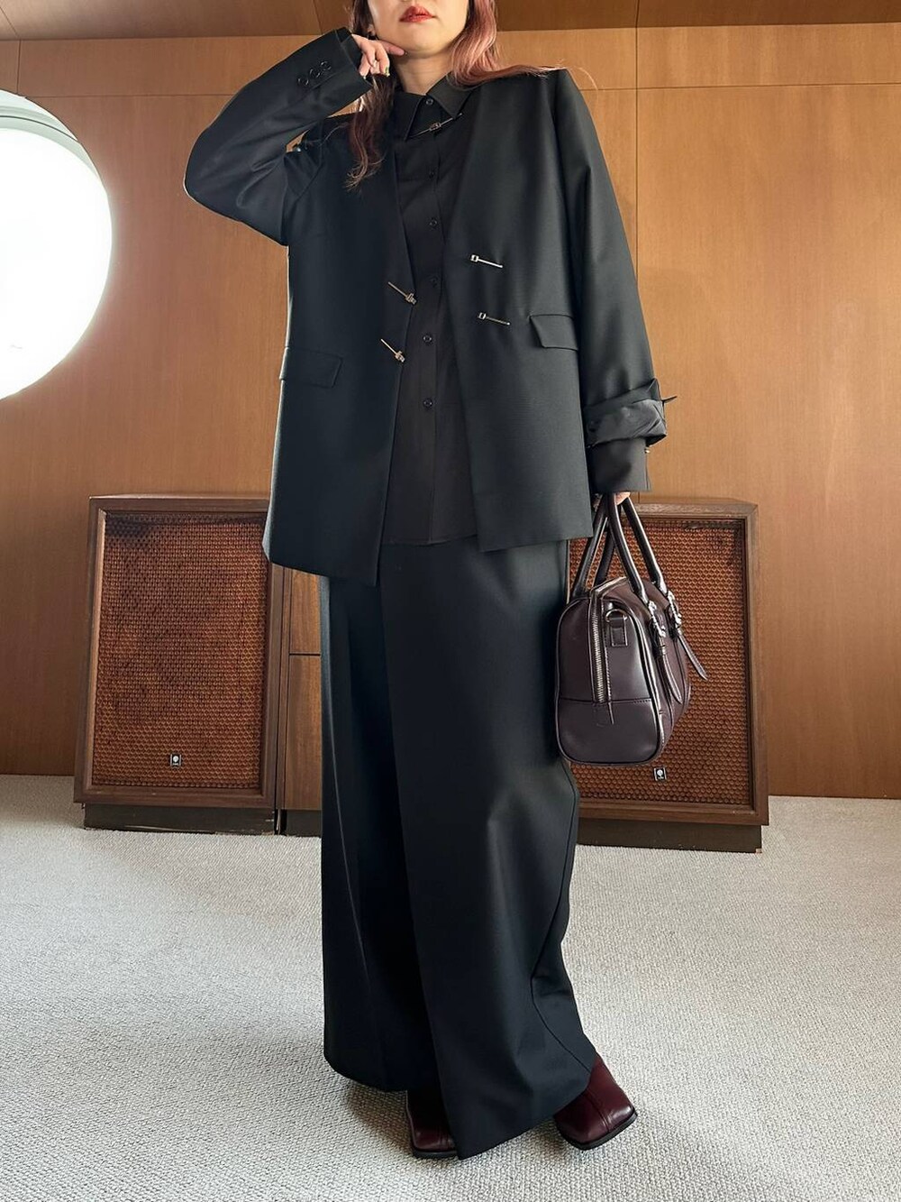 ブラウン系のボストンバッグ、レッド系のブーツを着用したレディースの秋コーディネートの6枚目の写真