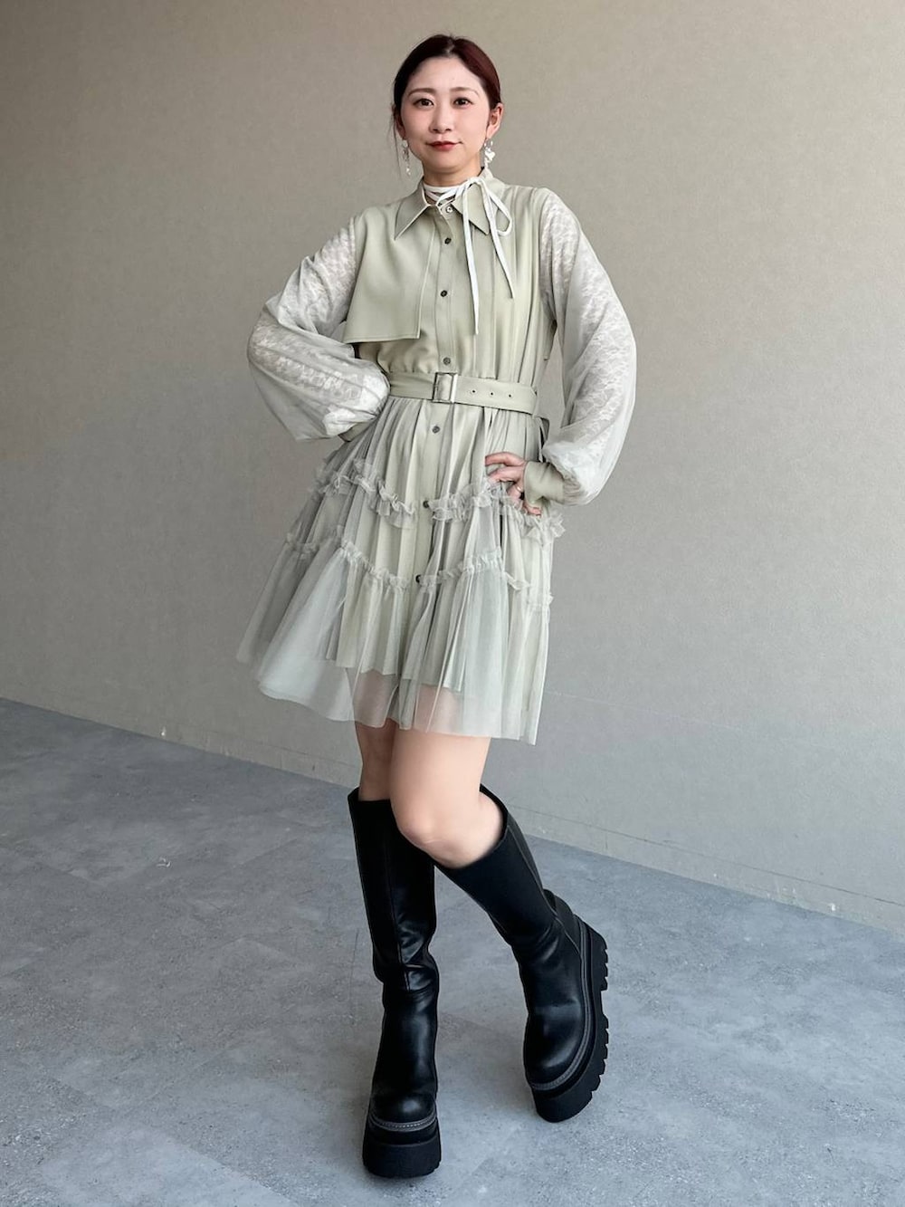 ブラック系のブーツ、ホワイト系のTシャツ/カットソー、イエロー系のワンピースを着用したレディースの冬コーディネートの6枚目の写真