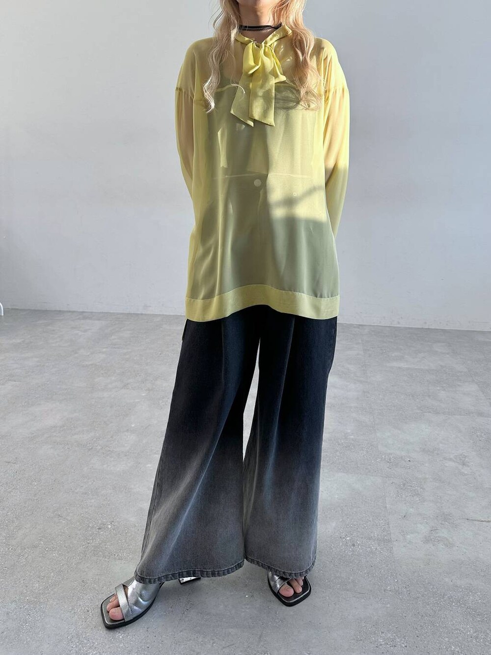 シルバー系のサンダル、ブラック系のデニムパンツ、イエロー系のTシャツ/カットソーを着用したレディースの春コーディネートの7枚目の写真