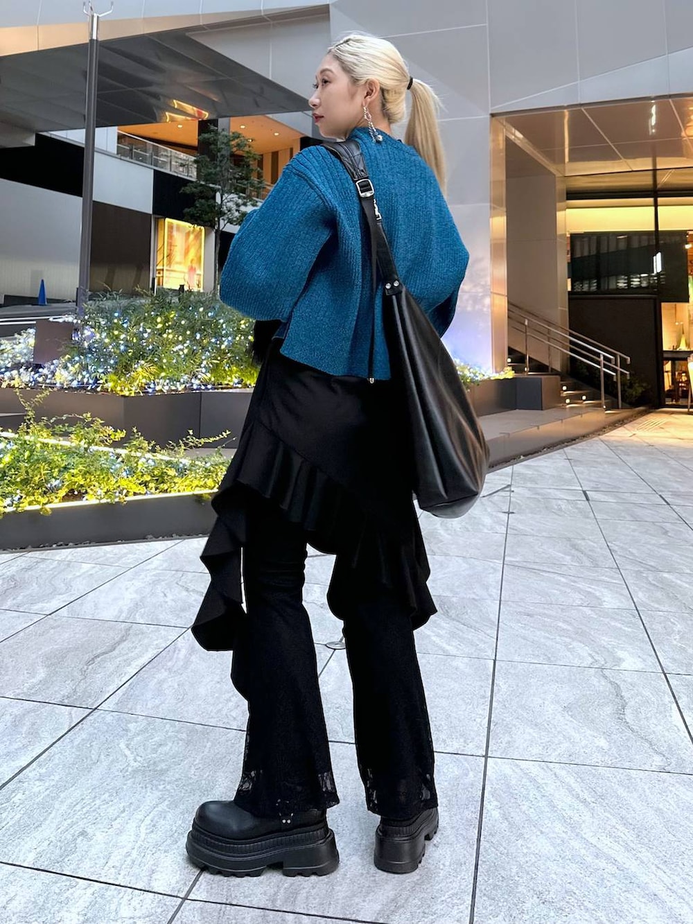 ブラック系のTシャツ/カットソー、ブラック系のブーツ、ブラック系のショルダーバッグを着用したレディースの冬コーディネートの3枚目の写真