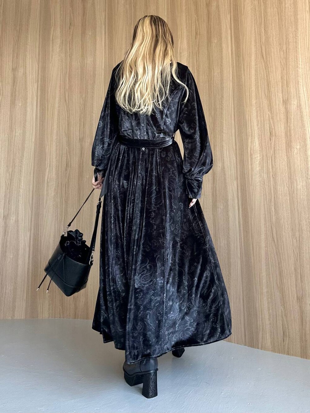 グレー系のワンピース、ブルー系のブーツ、ブラック系のショルダーバッグを着用したレディースの秋コーディネートの2枚目の写真