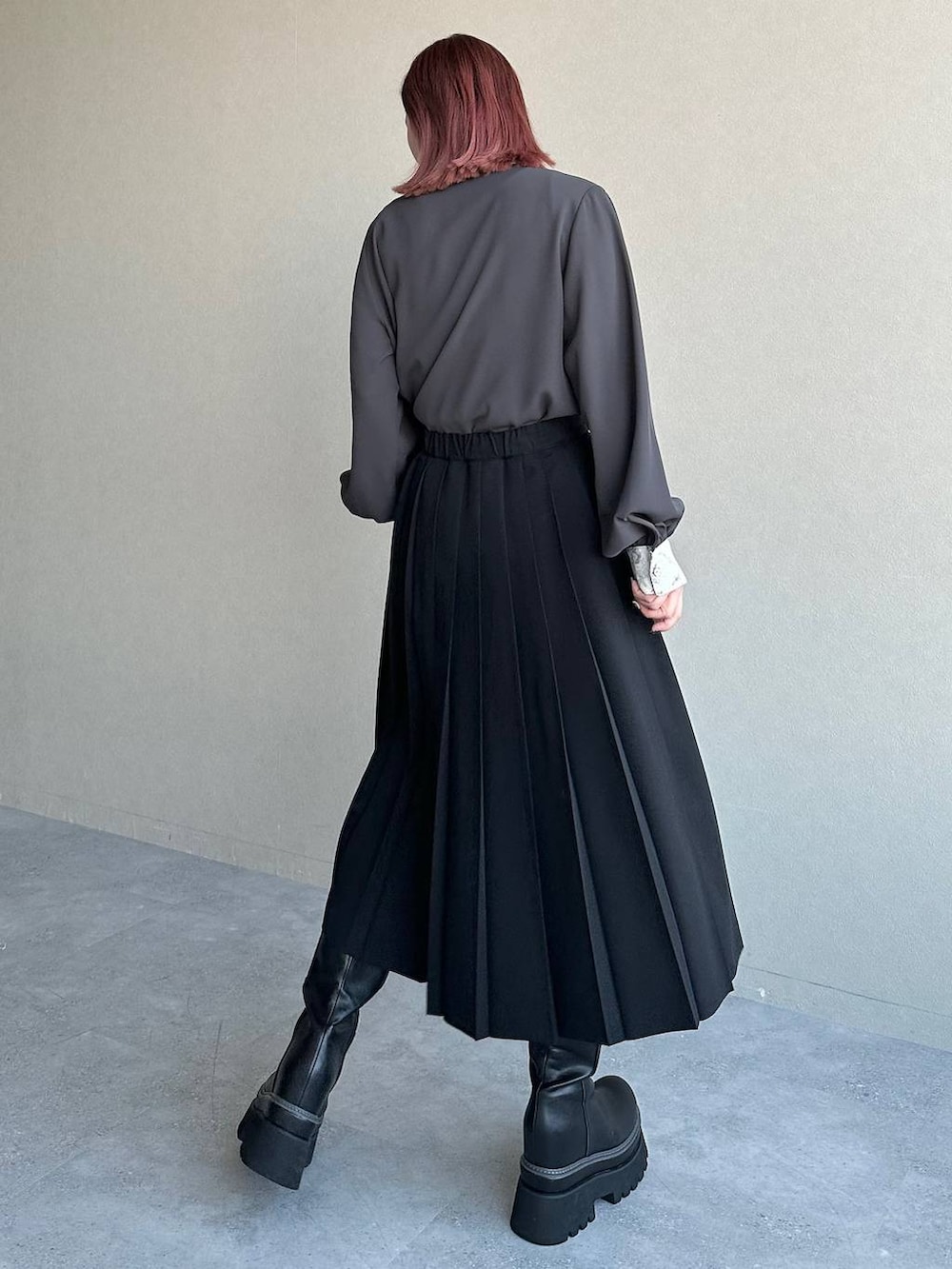 ブラック系のブーツ、グレー系のシャツ/ブラウス、ブラック系のスカートを着用したレディースの冬コーディネートの2枚目の写真