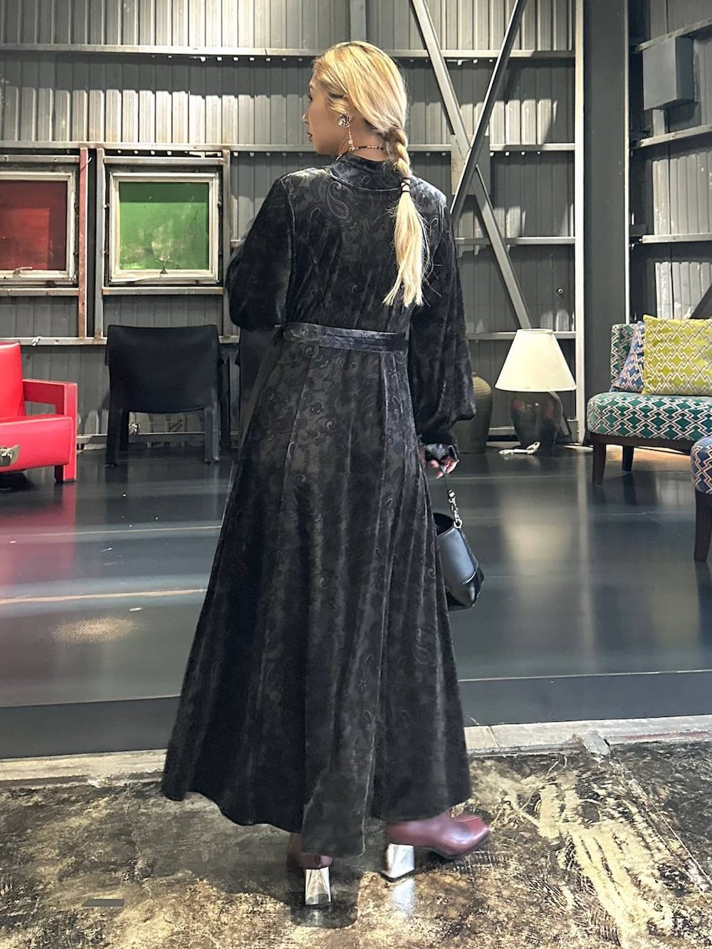 ブラック系のワンピース、レッド系のブーツ、ブラック系のショルダーバッグを着用したレディースの秋コーディネートの2枚目の写真